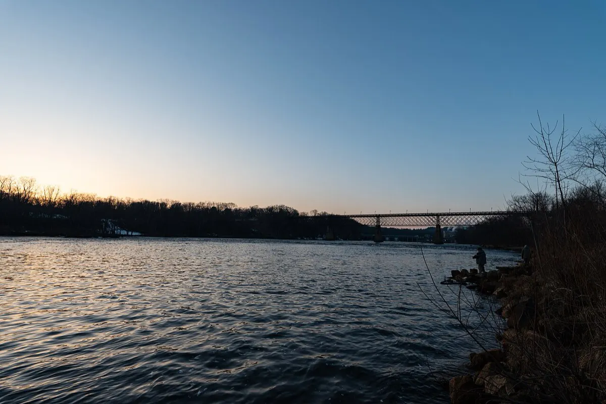 Anglers fishing a river at dusk